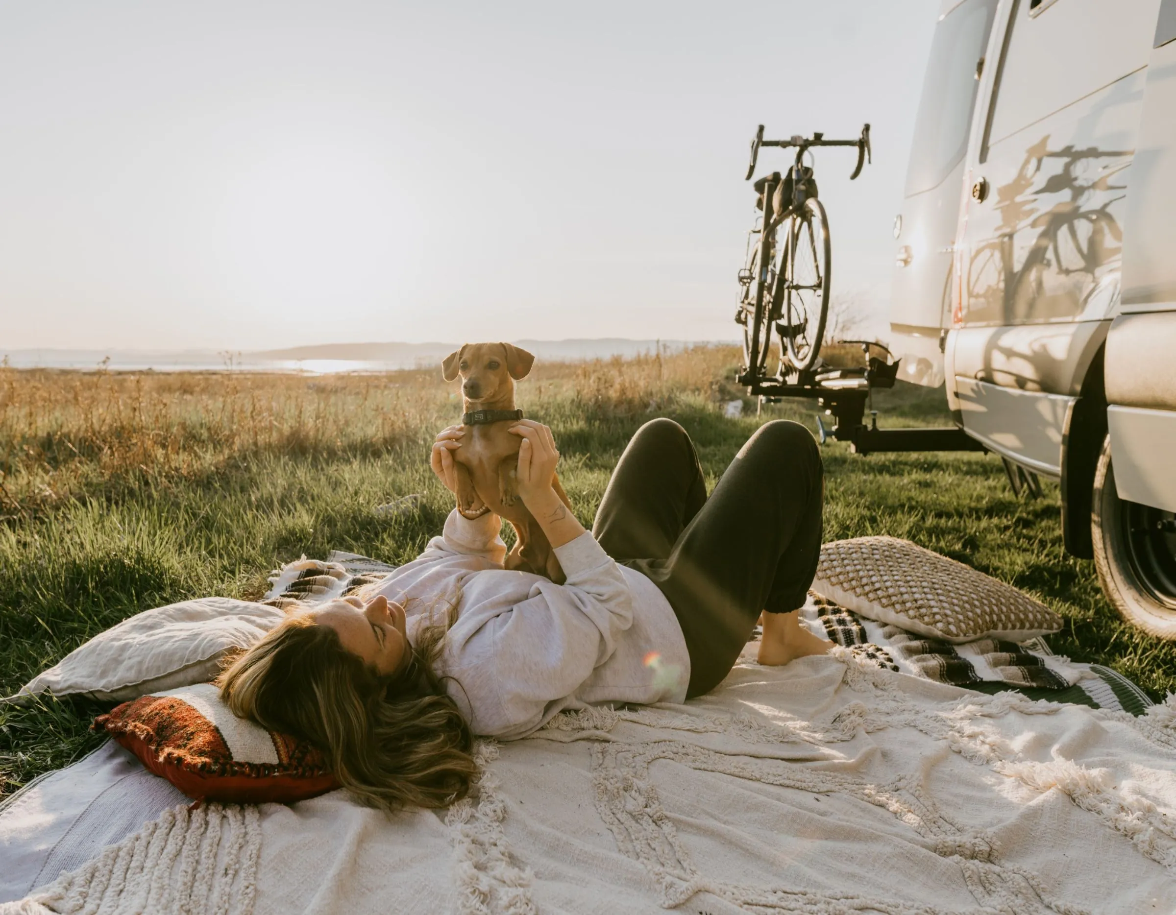 Détente au coucher du soleil devant le van avec son chien